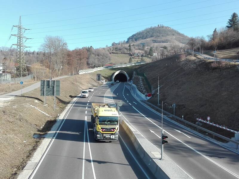 Eine zweispurige Straße in jede Richtung. Im Hintergrund ist ein Tunneleingang.