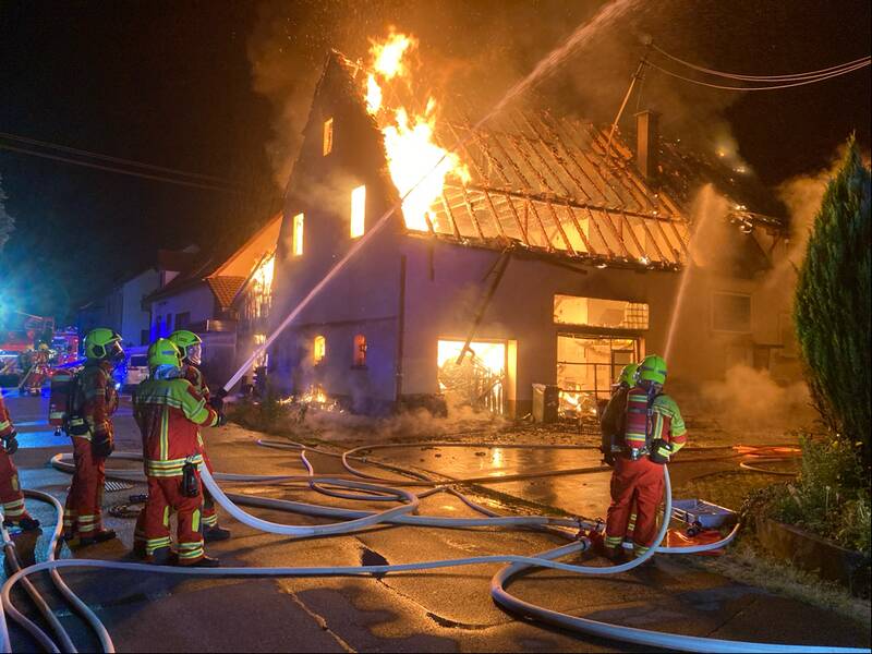 Feuerwehrmänner löschen ein Haus in Brand.