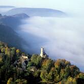 Luftbild auf das Schloss Lichtenstein, seitlich Nebel und Wald