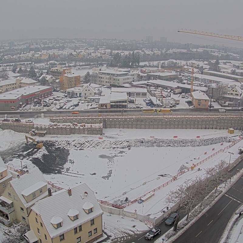 Eine Baugrube von oben. Die Baufläche ist mit Schnee bedeckt.