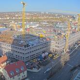 Eine Baustelle von oben. Die ersten Geschosse des Rohbaus sind schon sichtbar.